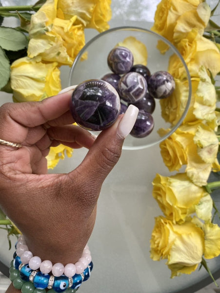 Amethyst works to relieves our minds of worry, stress, or tension. Amethyst helps to remove any mental distractions or clutter. Pictured are Chevron Amethyst Spheres in a bowl.